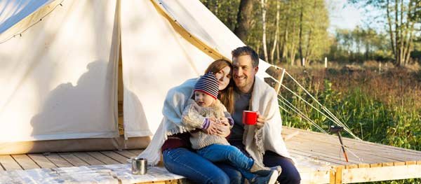 Family sitting outside a tent