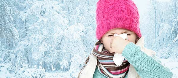 Little girl outside in winter blowing her nose