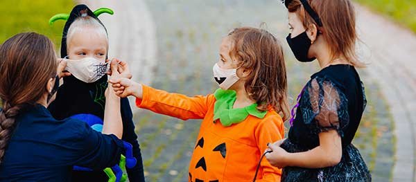 Kid out trick or treating with facemasks