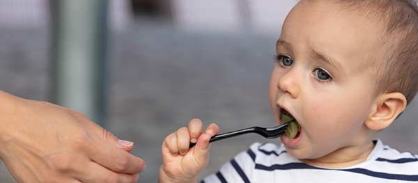Small boy eating a grape
