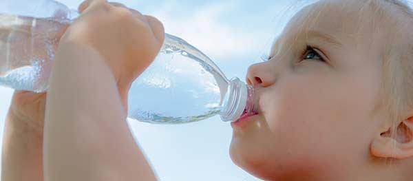 Small boy drinking bottle of water