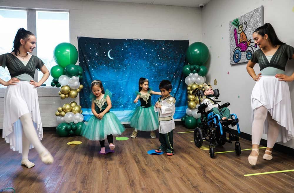 Group of small children at recital in costumes with teachers