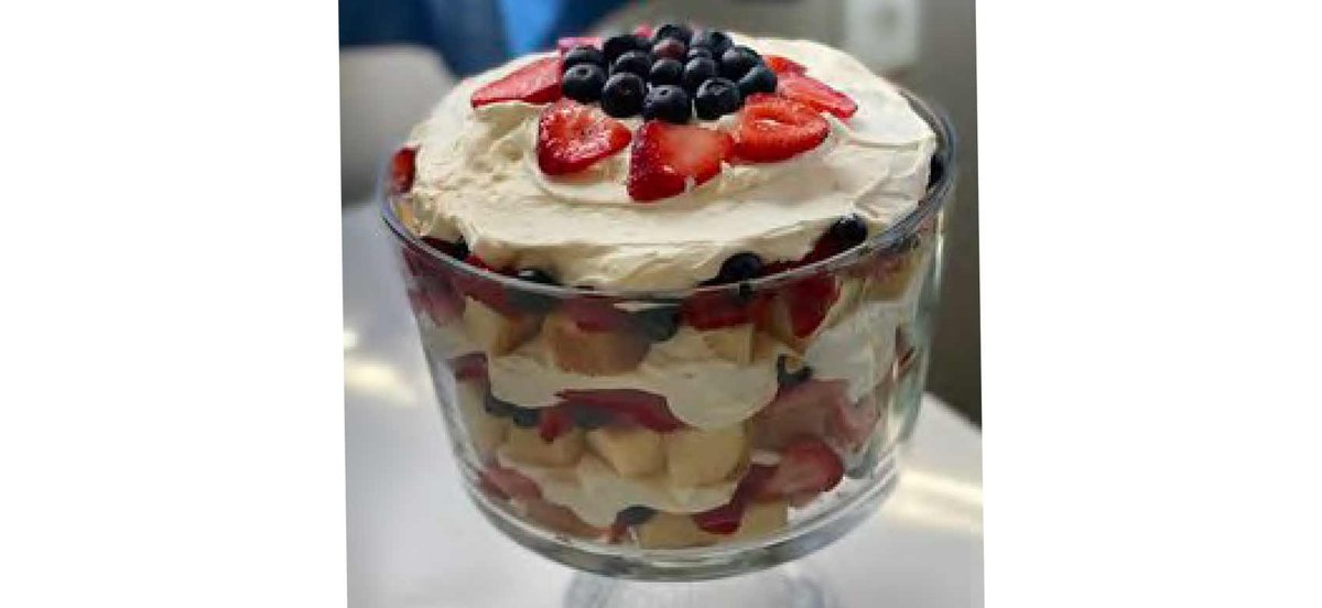 Trifle with strawberries and blueberries in a clear glass container