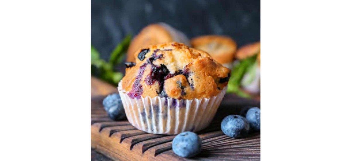 Blueberry muffin on table with fresh blueberries