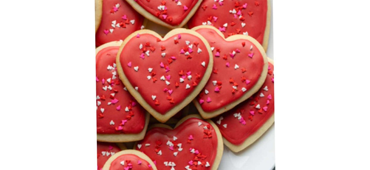 Stack of red heart cookies with sprinkles