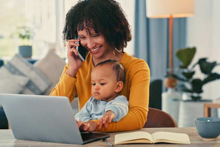 Mom sitting at laptop with small baby