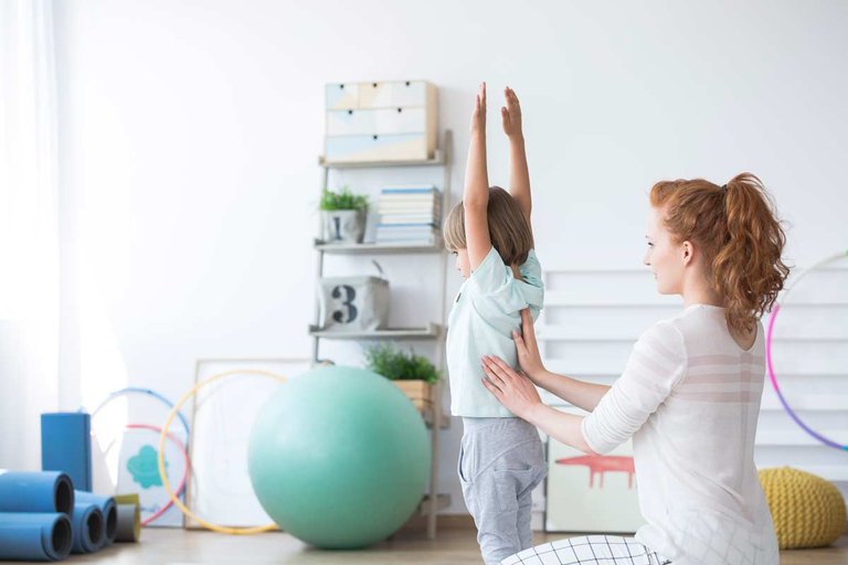 Nurse helping small child exercise