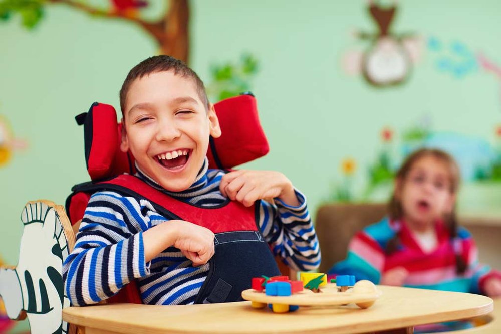 Young boy with big smile in wheelchair